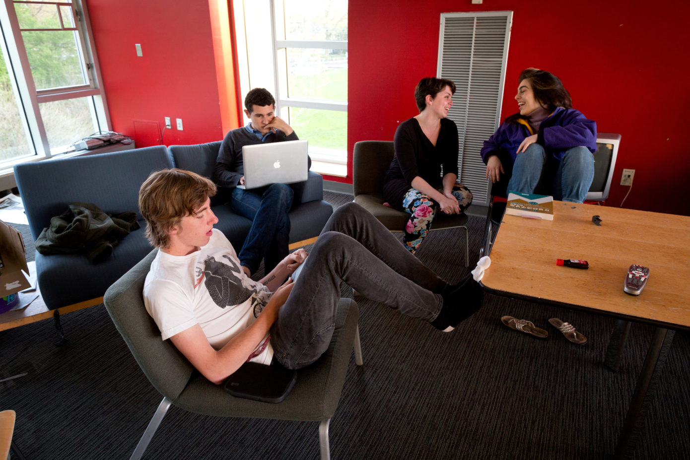 Swarthmore College students sitting in a dorm room reading on laptop computers and other devices.